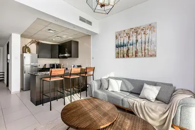 a living room with a couch and a table and a kitchen at 2b Stylish apart in JBR, near Beach&Marina Walk in Dubai