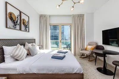 a bedroom with a bed and a desk and a window at 2b Stylish apart in JBR, near Beach&Marina Walk in Dubai