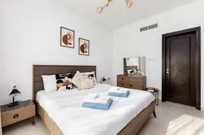 a bedroom with a large white bed with blue pillows at 2b Stylish apart in JBR, near Beach&Marina Walk in Dubai