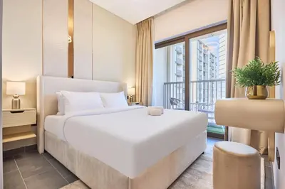 a bedroom with a large white bed and a window at STAY BY LATINEM Luxury 1BR Holiday Home CC 3313 Near Burj Khalifa in Dubai