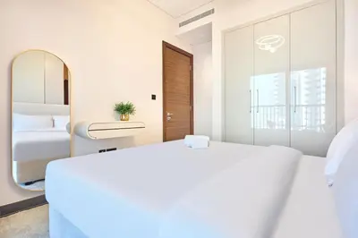 a bedroom with a large white bed and a mirror at STAY BY LATINEM Luxury 1BR Holiday Home CC 3313 Near Burj Khalifa in Dubai