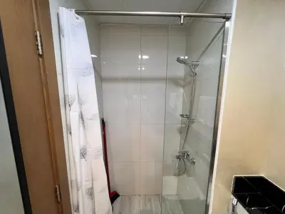 a shower with a glass door in a bathroom at Binghatti Millennium Studio Apartment in Dubai
