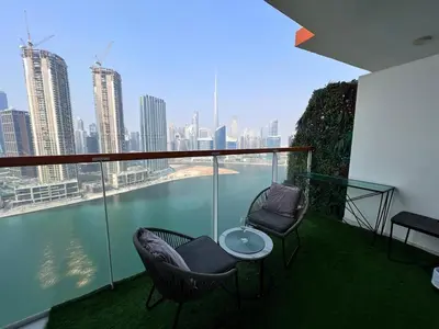 a balcony with chairs and a table and a view of the city at Binghatti Millennium Studio Apartment in Dubai