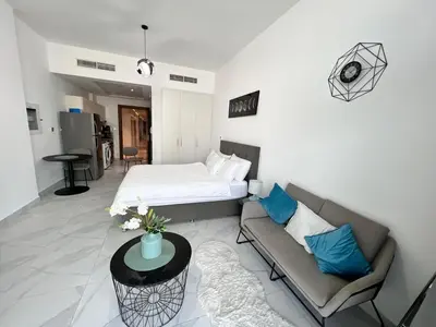 a living room with a bed and a couch at Binghatti Millennium Studio Apartment in Dubai