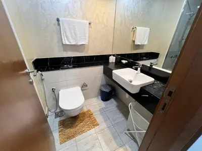 a bathroom with a white toilet and a sink at Binghatti Millennium Studio Apartment in Dubai