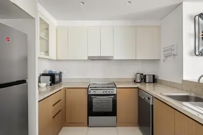 a kitchen with white cabinets and a stove top oven at VayK - Spacious 2BR in Dubai Creek Harbour in Dubai