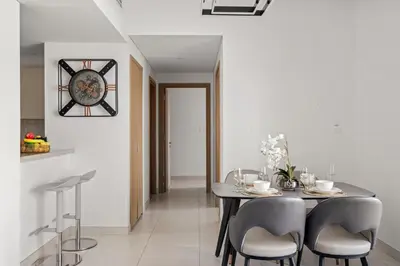 a dining room with a table and chairs and a clock at VayK - Spacious 2BR in Dubai Creek Harbour in Dubai