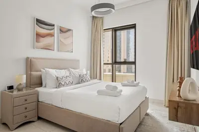 a white bedroom with a large bed and a window at VayK - Spacious 2BR in Dubai Creek Harbour in Dubai
