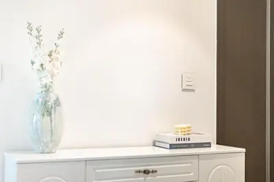 a white cabinet with a vase on top of it at Central 2BR Downtown Views EB in Dubai