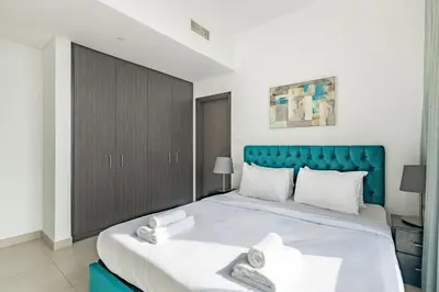 a bedroom with a large bed with a blue headboard at Central 2BR Downtown Views EB in Dubai