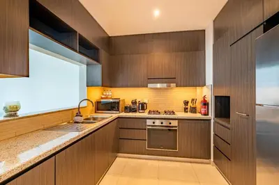 a kitchen with wooden cabinets and a sink at Central 2BR Downtown Views EB in Dubai