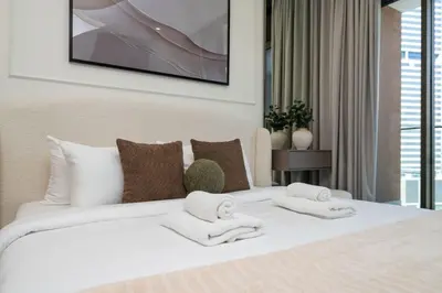 a bedroom with a white bed with towels on it at Peninsula Five Luxurious Business Bay Studio in Dubai