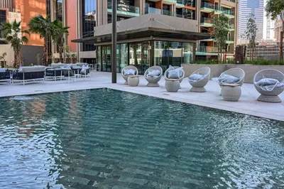 a pool of water with chairs and tables in a building at Peninsula Five Luxurious Business Bay Studio in Dubai