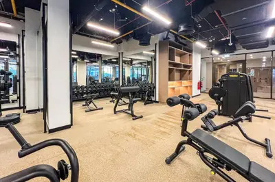 a gym with rows of treadmills and exercise bikes at Peninsula Five Luxurious Business Bay Studio in Dubai
