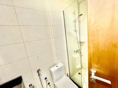 a bathroom with a toilet and a glass shower at Perfect choice for a big family in Dubai