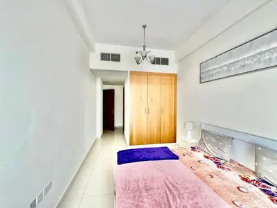 a bedroom with a bed with a purple blanket at Perfect choice for a big family in Dubai