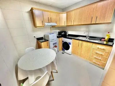 a small kitchen with a white table and a stove at Not far from metro Spacious in Dubai