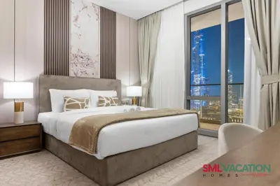 a bedroom with a large bed and a large window at SML Vacation Homes at Vida Dubai Mall - Apartments with Burj Khalifa Views & access to the Dubai Mall in Dubai