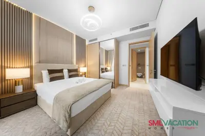 a bedroom with a large bed and a flat screen tv at SML Vacation Homes at Vida Dubai Mall - Apartments with Burj Khalifa Views & access to the Dubai Mall in Dubai