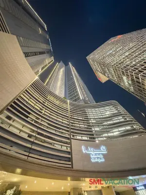 a tall building with a view of it at night at SML Vacation Homes at Vida Dubai Mall - Apartments with Burj Khalifa Views & access to the Dubai Mall in Dubai