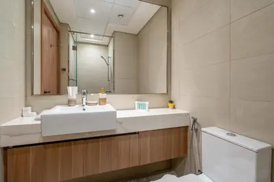 a bathroom with a sink and a mirror and a toilet at Stylish Studio with Gym & Pool in Azizi Riviera in Dubai