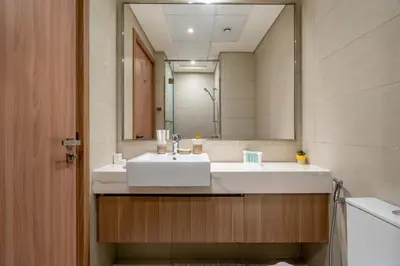 a bathroom with a sink and a large mirror at Stylish Studio with Gym & Pool in Azizi Riviera in Dubai