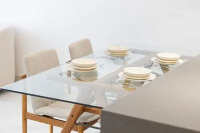 a glass table with plates and bowls on it at Elegant 1 Bedroom Apartment with Balcony & Lagoon in District One in Dubai