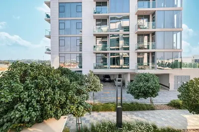 an apartment building with trees in front of it at Elegant 1 Bedroom Apartment with Balcony & Lagoon in District One in Dubai
