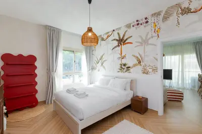 a bedroom with a white bed and a red chair at Al Dhafrah 4, The Greens - Onelink in Dubai