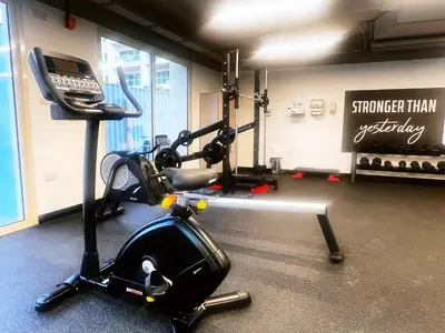 a room with a gym with a phone on a treadmill at Al Dhafrah 4, The Greens - Onelink in Dubai