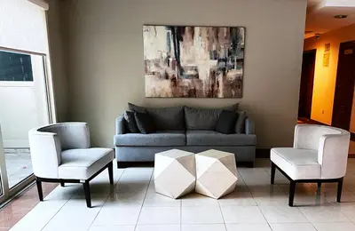 a living room with a couch and two chairs at Al Dhafrah 4, The Greens - Onelink in Dubai