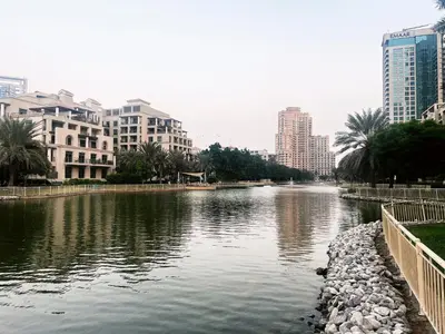 a river in the middle of a city with buildings at Al Dhafrah 4, The Greens - Onelink in Dubai