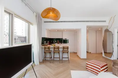 a kitchen and living room with a table and chairs at Al Dhafrah 4, The Greens - Onelink in Dubai