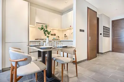 a dining room with a table and chairs at STAY BY LATINEM Luxury 1BR Holiday Home CB 2601 Near Burj Khalifa in Dubai