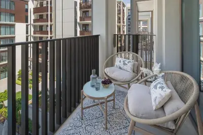 two chairs and a table on a balcony at Frank Porter - Grove at Creek Beach Building in Dubai