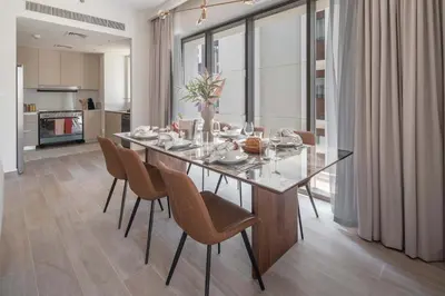 a dining room with a glass table and chairs at Frank Porter - Grove at Creek Beach Building in Dubai