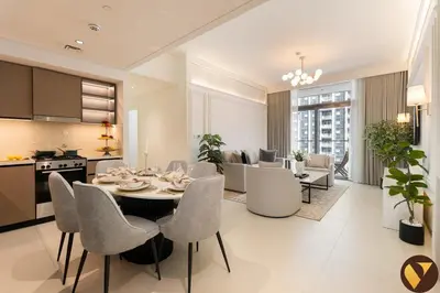 a kitchen and living room with a table and chairs at Vogue Downtown Burj Crown near Burj Khalifa and Dubai Mall, Three Bedroom plus Kids Room Apartment with Large Balcony and Skyline view, Access to all Amenities in Dubai