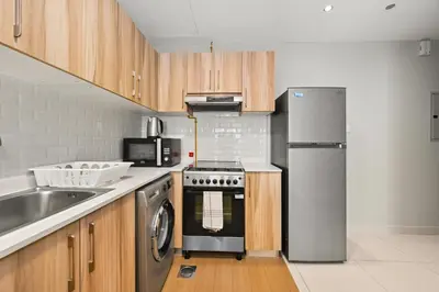 a kitchen with a stove and a refrigerator at Modern Luxury 2BR Apartment In Dubai Sports City in Dubai