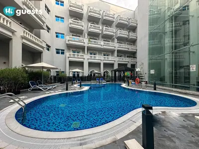 a large swimming pool in front of a building at HiGuests - Experience Luxury 1BR Living at Autumn-1A in JVC in Dubai