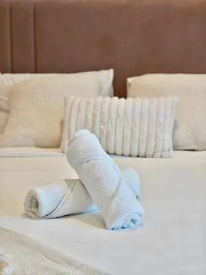 a white sock animal laying on a bed at Stylish New Studio Apartment with Balcony in Dubai