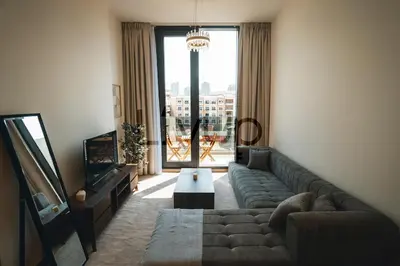 a living room with a couch and a large window at Stylish 1-Bedroom in JVC with large balcony in Dubai