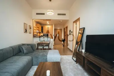 a living room with a couch and a flat screen tv at Stylish 1-Bedroom in JVC with large balcony in Dubai