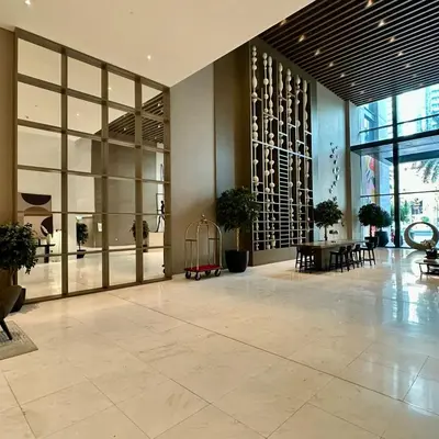 a lobby of a building with tables and potted plants at Boulevard Heights Downtown Perfect Location High floor Luxury Apartment! in Dubai