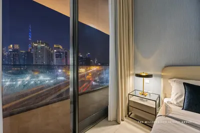 a bedroom with a view of a city at night at Burj Khalif View from Bedroom - Millionaire Residence in Business Bay Dubai in Dubai