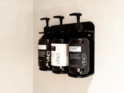 a shelf with four bottles of hair products on it at Vida Residence Dubai Mall by Propigo in Dubai
