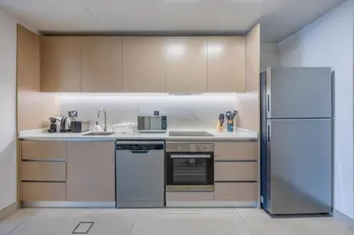 a kitchen with white appliances and a refrigerator at Skyview Luxe 4BR - Elegant Sea & Ain Dubai View in Dubai
