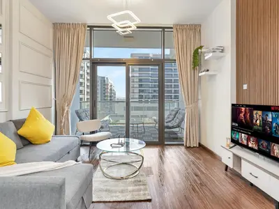 a living room with a couch and a tv at Sleek 1BR Apt Free Pool & Gym Access in Dubai