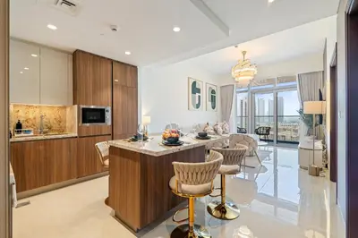 a kitchen and living room with a island with chairs at Classy and Chic 2BR in Downtown with Burj Khalifa View in Dubai