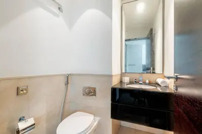 a bathroom with a toilet and a sink and a mirror at Marina Views & 5-Star Comfort Dubai Marina in Dubai