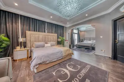 a bedroom with a large bed with a chandelier at World Class Luxurious 5 BDR Villa In Palm Jumeriah in Dubai